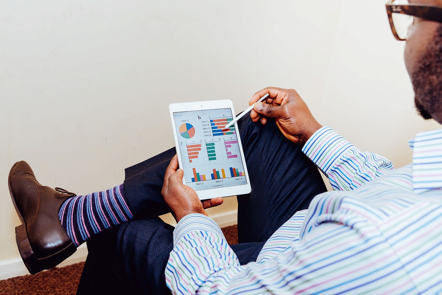 Man with Ipad showing bar charts on the screen